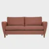 KUURA-sohva-2-5ist-180x85cm-stark602-pahkina-Finsoffat Leveämpi 2 hengen Kuura-sohva ruosteenpunaisella kankaalla verhoiltuna ja jalkoina pähkinän väriset puujalat kuvattuna suoraan edestäpäin harmaata taustaa vasten.