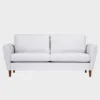 KUURA-sohva-2-5ist-180x85cm-stark607-pahkina-Finsoffat Leveämpi 2 hengen Kuura-sohva vaalean harmaalla kankaalla verhoiltuna ja jalkoina pähkinän väriset puujalat kuvattuna suoraan edestäpäin harmaata taustaa vasten.