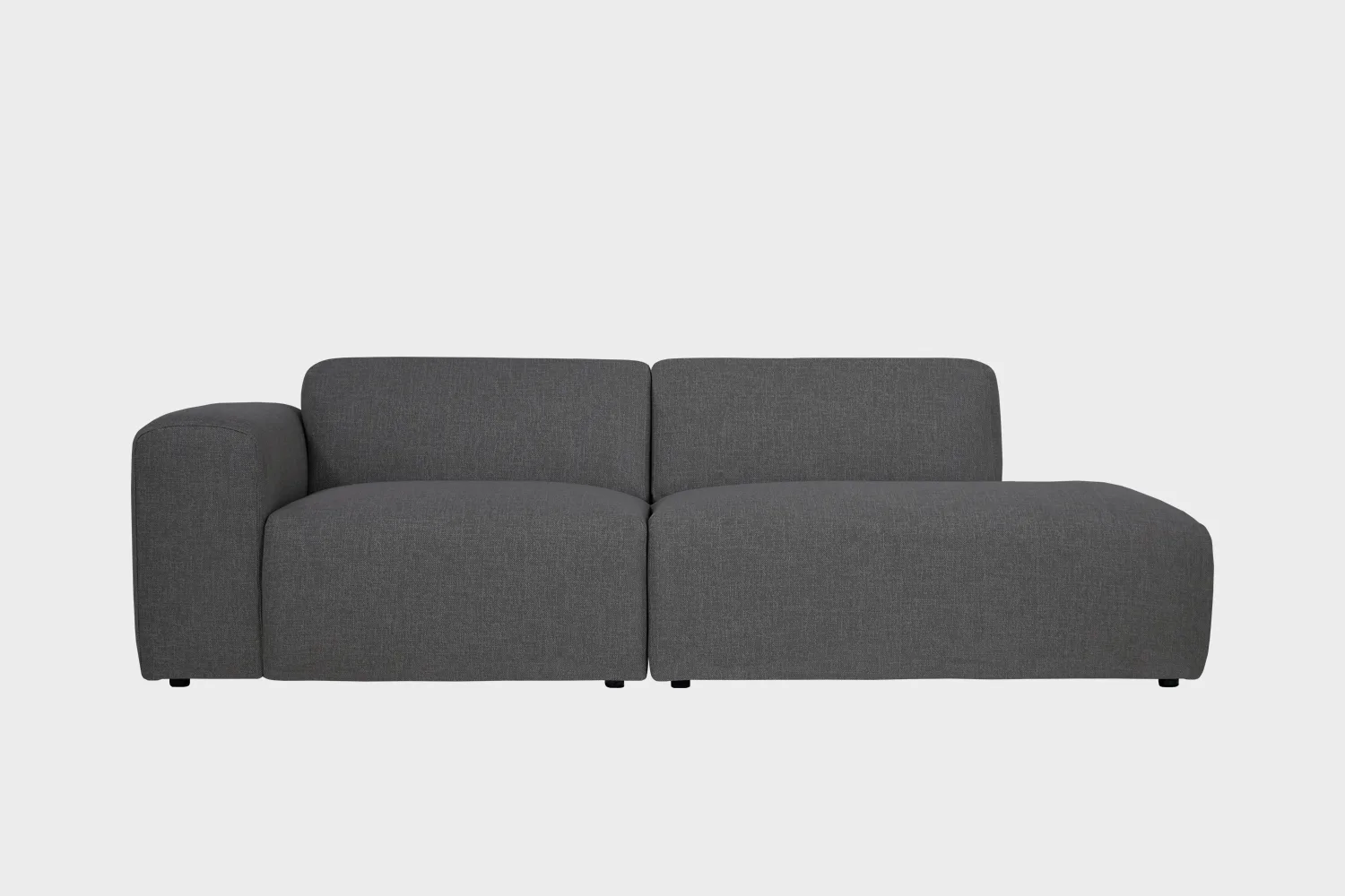 BOHO-avodivaani-do-257x107cm-sacco59-finsoffat Boho-avodivaanisohva tummanharmaalla kankaalla verhoiltuna, käsinoja vasemmalla ja divaaniosuus oikealla vaaleaa taustaa vasten.