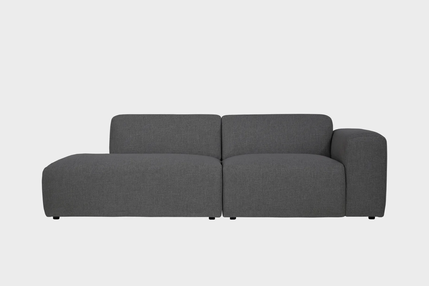 Boho-avodivaanisohva tummanharmaalla kankaalla verhoiltuna, käsinoja oikealla ja divaaniosuus vasemmalla vaaleaa taustaa vasten.