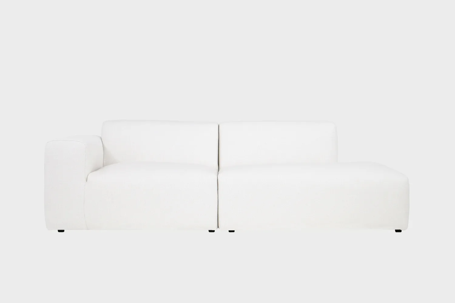 BOHO-avodivaani-do-257x107cm-muru484-finsoffat Boho-avodivaanisohva valkoisella bukleekankaalla verhoiltuna, käsinoja vasemmalla ja divaaniosuus oikealla vaaleaa taustaa vasten.