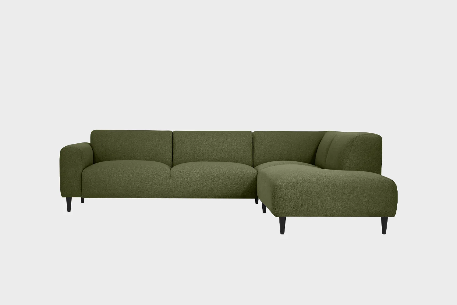 Vihreä avokulmasohva mustilla puujaloilla ja divaanin puoli sohvan oikealla puolella edestä päin katsottuna.