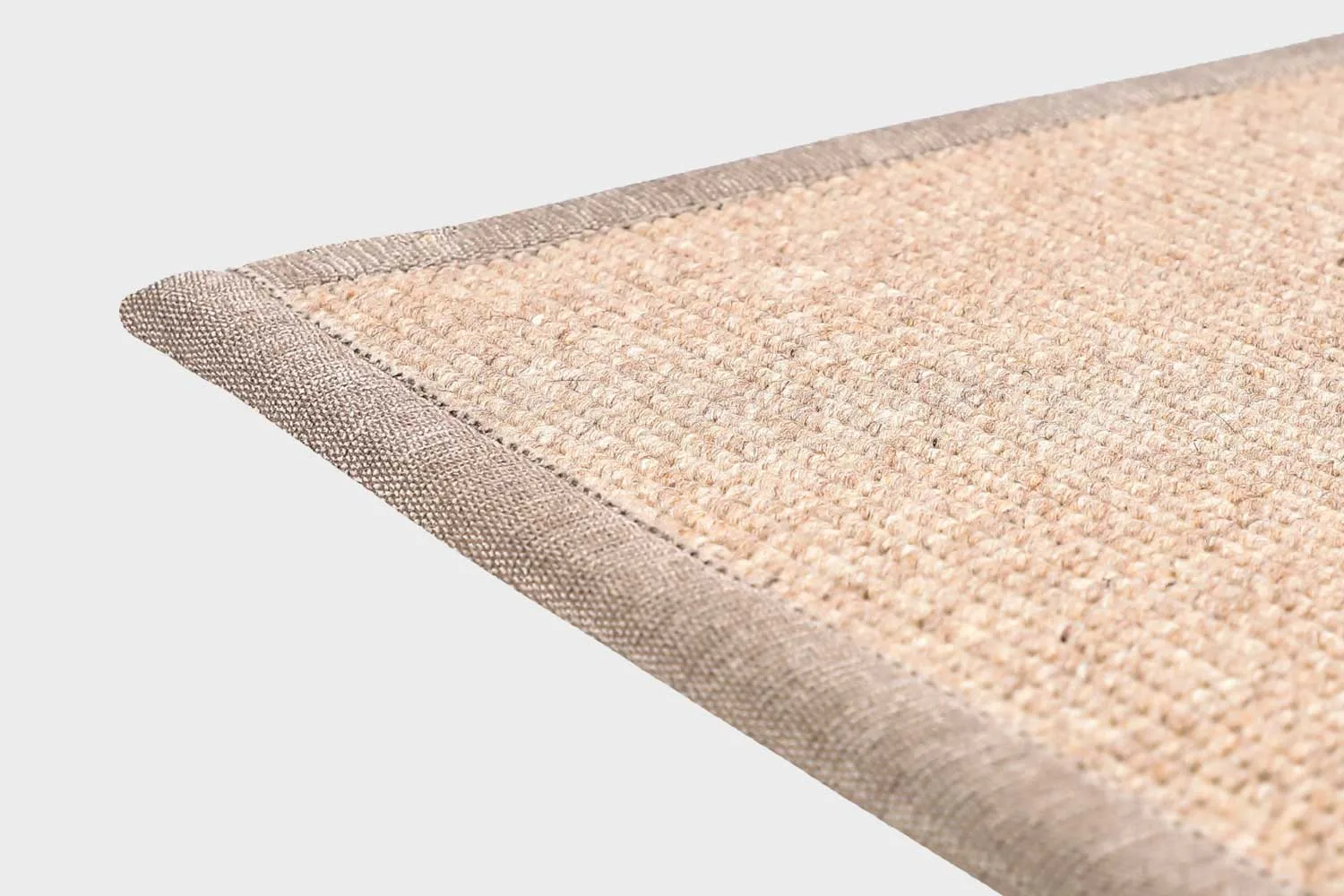 Beige VM Carpet Esmeralda matto. Lähikuva maton kulmasta, josta näkyy kanttaus ja maton materiaali.