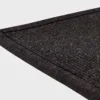 Musta VM Carpet Esmeralda matto. Lähikuva maton kulmasta, josta näkyy kanttaus ja maton materiaali.