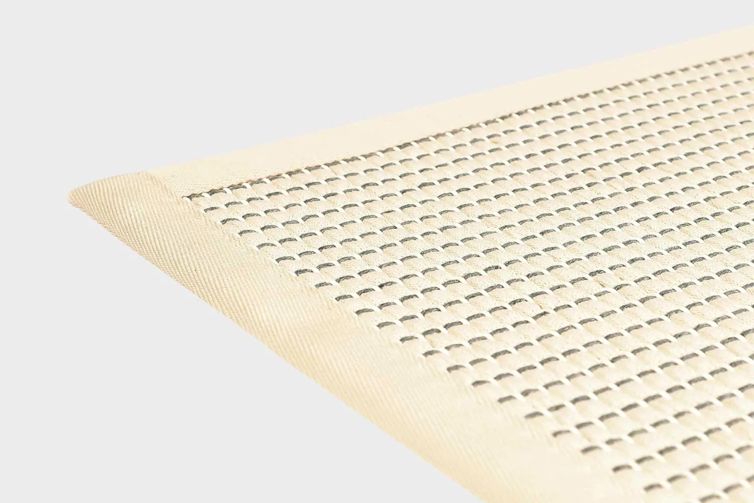 Valkoinen VM Carpet Lyyra 2 matto. Lähikuva maton kulmasta, josta näkyy kanttaus ja maton materiaali.