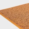VM-Carpet-Tweed-52-keltainen Keltainen VM Carpet Tweed matto. Lähikuva maton kulmasta, josta näkyy kanttaus ja maton materiaali.