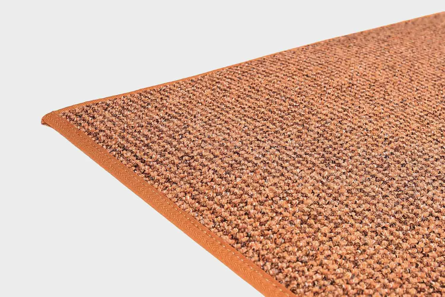 VM-Carpet-Tweed-64-terra Terran värinen VM Carpet Tweed matto. Lähikuva maton kulmasta, josta näkyy kanttaus ja maton materiaali.