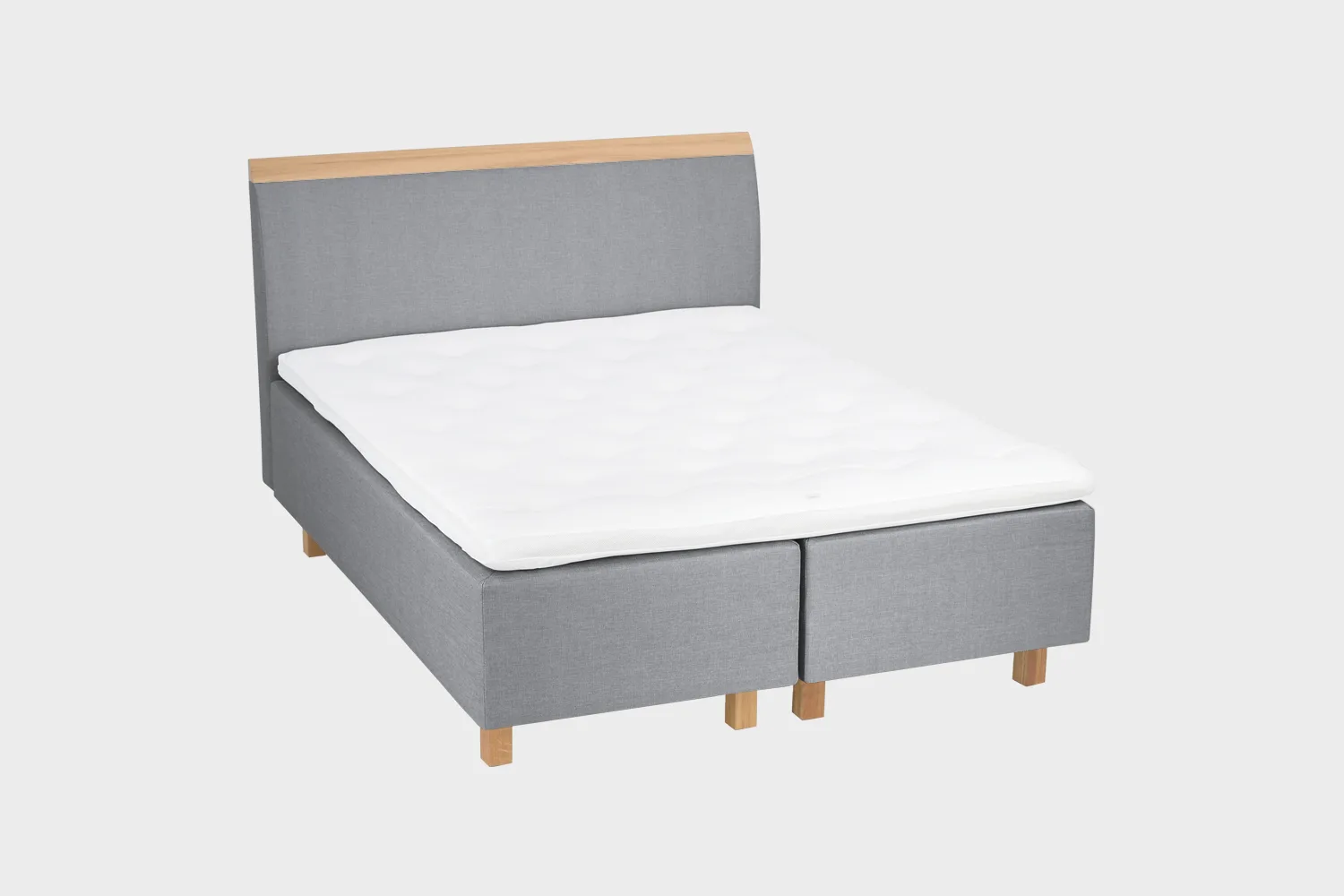 savoy-comfort-runkosanky-160x200cm-das51-tammi-finsoffat Harmaa runkosänky 160x200 cm tammen värisillä jaloilla ja harmaalla sängynpäädyllä, jossa tammen värinen puukoristelista yläosassa. Kuvattuna viistosti vaaleanharmaata taustaa vasten.