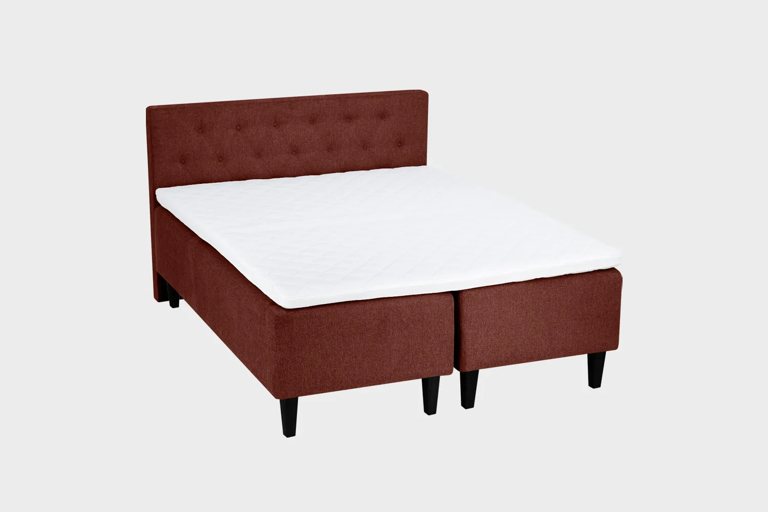 Punaruskea 180 cm leveä ja 200 cm pitkä runkopatja napillisella sängynpäädyllä ja mustan värisillä kantikkailla puujaloilla.