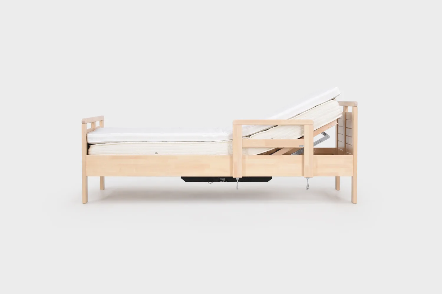 moottoroitu-seniorisanky-80x200cm-korkeus-37cm-koivu-kohotettu-paaty-sivukuva-finsoffat Koivunvärinen moottoroitu seniorisänky varustettuna nousutuella kuvattuna sivusta pääty kohotettuna.